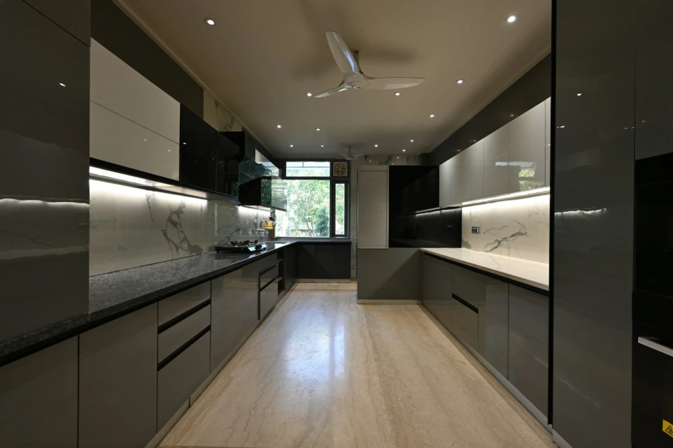 a kitchen with black and white cabinets and a ceiling fan